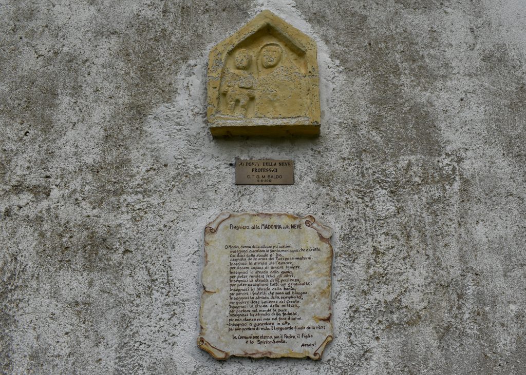 The prayer on the Madonna delle Neve facade
